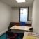 Bureau avec table, chaises, climatiseur, bouilloire, imprimante et documents.