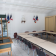 Salle de classe avec tables, chaises, tableau et affichages muraux.