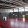 Salle de sport avec filets, paniers de basket, et gradins.