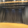 Scène de théâtre avec rideaux et éclairage.