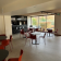 Salle avec tables rondes, chaises, comptoir et distributeur automatique.