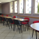 Salle avec tables, chaises, micro-ondes, frigo et distributeur de boissons.