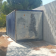 Conteneur métallique à côté d'un mur en blocs de béton. Arbre à gauche.