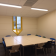 Salle avec table, chaises, fenêtre et éclairage encastré.