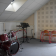 Pièce avec batterie, pupitre, ampli, chaises et tableau d'acoustique.