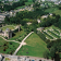 Vue aérienne d'un château, de jardins et de bâtiments environnants.
