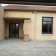Entrée d'un bâtiment avec porte, fenêtres et panneau indiquant la salle de la fontaine.