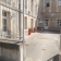 Cour intérieure avec bâtiments, portes, fenêtres, pots de fleurs et bancs.