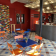 Salle avec tables, chaises, comptoir, et étagères. Mur coloré et sol carrelé.