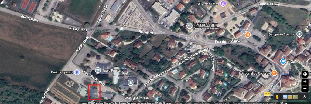 Image satellite d'un quartier avec rues, bâtiments, écoles et commerces.