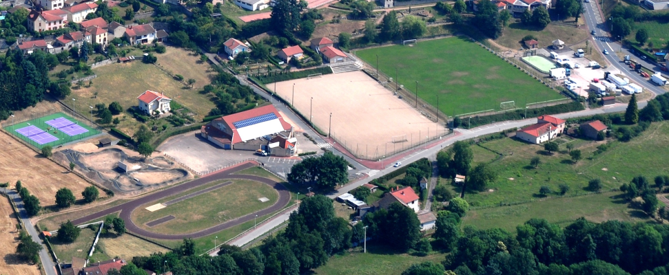 Complexe sportif avec terrains, pistes, bâtiments et parking.