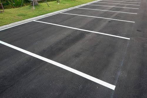 Parking avec places marquées au sol.