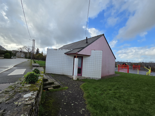Maisonnette en périphérie de route avec terrain de jeux.