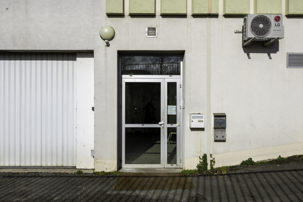 Extérieur avec porte, boîtes aux lettres, climatiseur et garage.