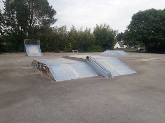 Skatepark avec rampes et modules.