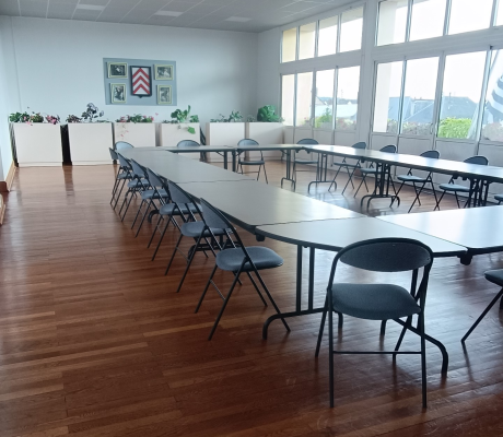 Salle avec tables, chaises, et plantes.