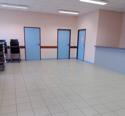 Pièces avec portes bleues et chariot métallique.