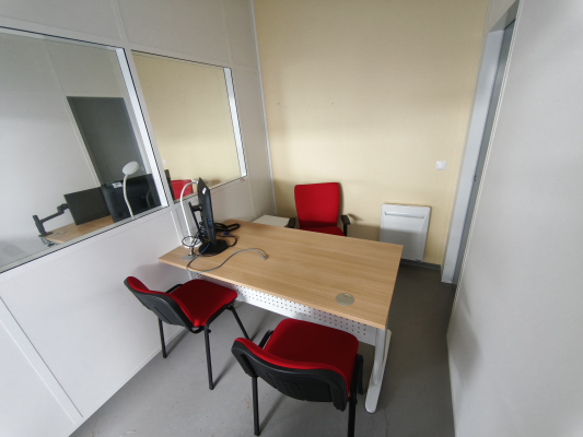 Bureau avec table, chaises, support pour ordinateur portable et radiateur.