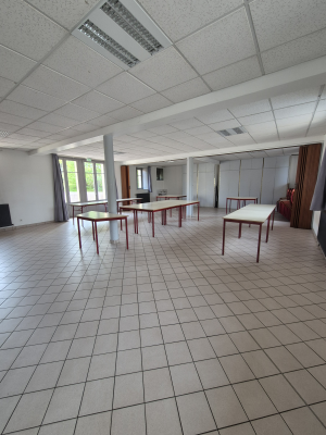 Salle avec tables, chaises, et colonnes.