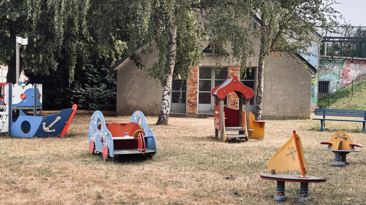 Aire de jeux avec toboggan, bateau, cabane et balançoire.