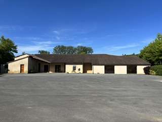 Bâtiment bas avec parking vide.