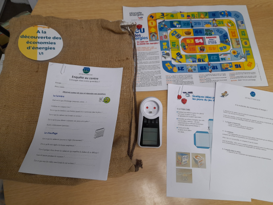 Jeu de société avec documents, jeton et dés sur table.