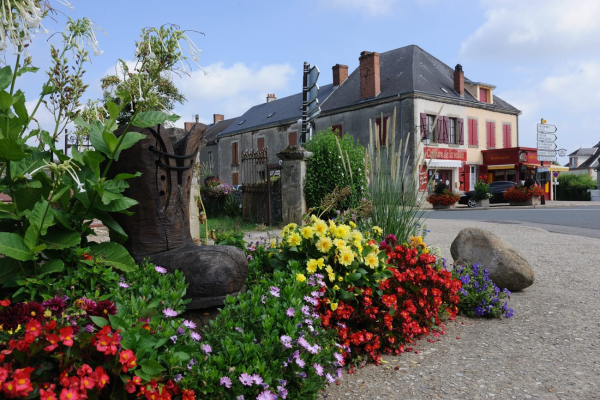"Rond-point avec bottes, fleurs, pierres et bâtiments."