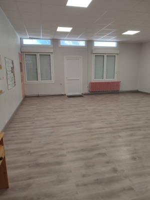 Pièce vide avec fenêtres, porte, radiateur et éclairage au plafond.