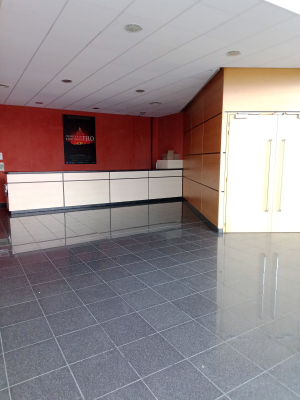 Pièce avec meubles en bois, comptoir blanc, porte et grande fenêtre.