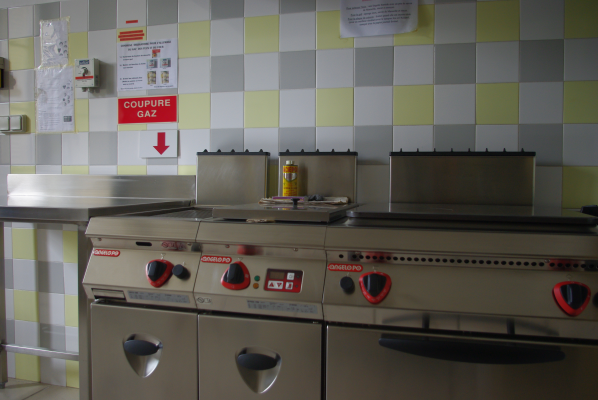 Cuisine avec plaques de cuisson, panneaux de commande, canette et panneau "Coupeure Gaz".