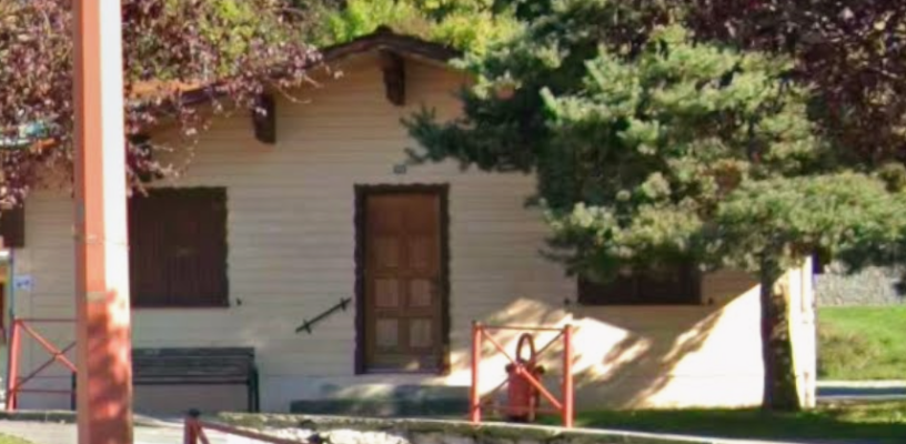 Maison avec porte, fenêtres et entrée partiellement bloquée par un arbre.