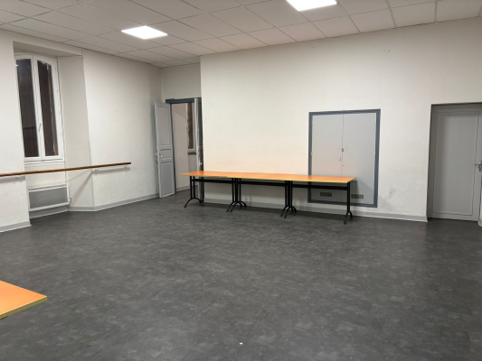 Salle vide avec table, portes et radiateurs.