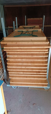 Chariot avec tables en bois empilées.