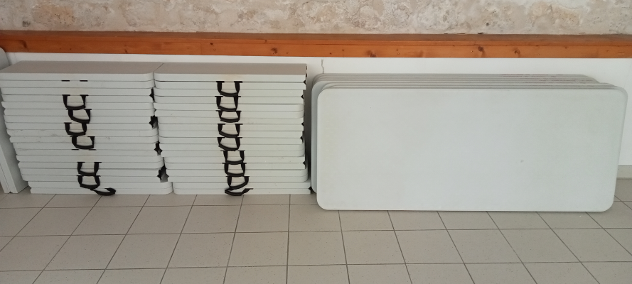 Piles de plaques de plâtre contre un mur.