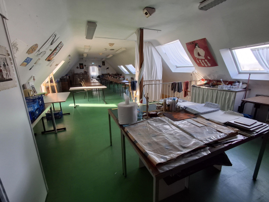 Atelier avec tables, outils, fenêtres et rangements.