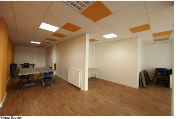 Pièce vide avec table, chaises, radiateur, et étagères.