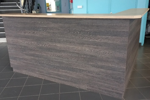 Comptoir en bois avec plan de travail, sols carrelés, escaliers et murs peints.