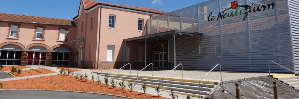 Bâtiment avec entrée principale, rampes d'accès, et enseigne "le Neutizium".