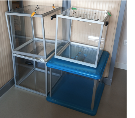 Deux cages en verre avec base bleue.