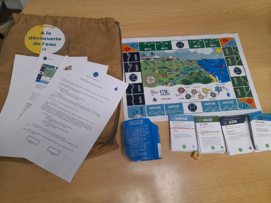 Jeu de société avec plateau, cartes, dés, jetons et règles sur table en bois.