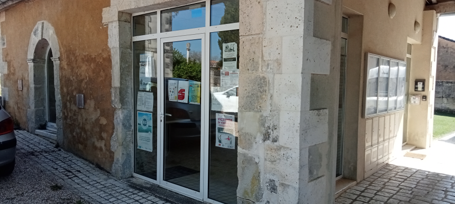 Bâtiment avec porte, fenêtres et affiches.