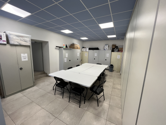 Salle avec table, chaises, armoires et étagères.