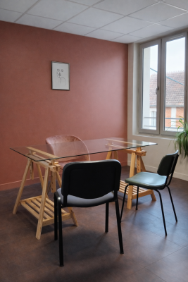 "Pièce avec table en verre, chaises, étagères, plante, fenêtre et cadre mural."