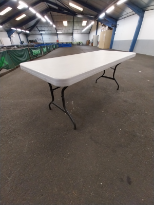 Table blanche sur tréteaux dans un entrepôt.