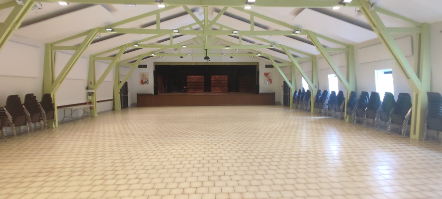 Salle avec chaises, podium, structure métallique, éclairage.