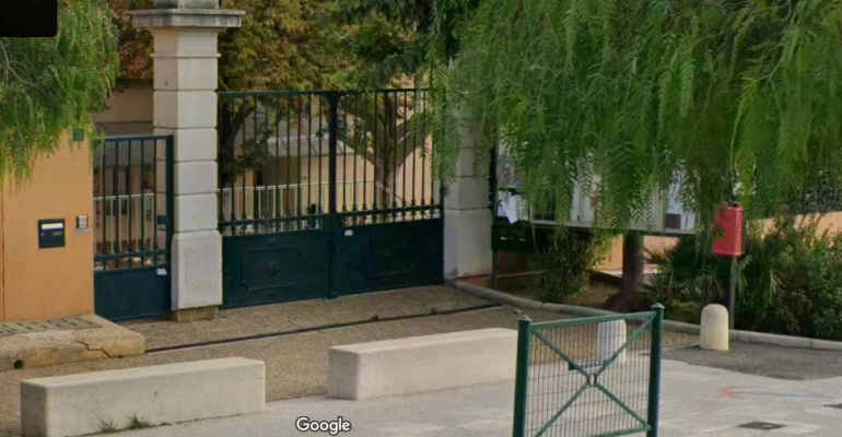 Entrée avec portail, murs, boîtes aux lettres, boîte à déchets, arbres et allée.