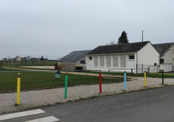 Bâtiments, terrains de sport, poubelles, poteaux colorés, passage piéton.