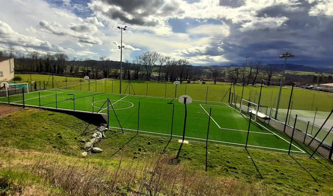 Terrain de foot avec filets, buts et projecteurs.