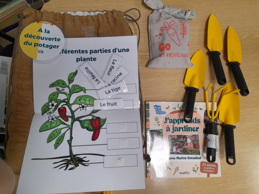 Matériel de jardinage avec affiche éducative, sacs et outils.